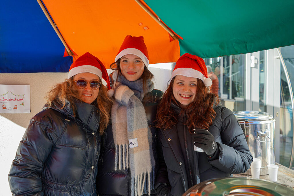 Internatsleiterung Anita Mukasa mit Ihren Schützlingen aus der Wolffsburg am Stand für Punsch und Glühwein.